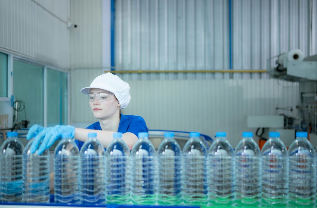 Drinking water factory worker at a production line of drinking water factory